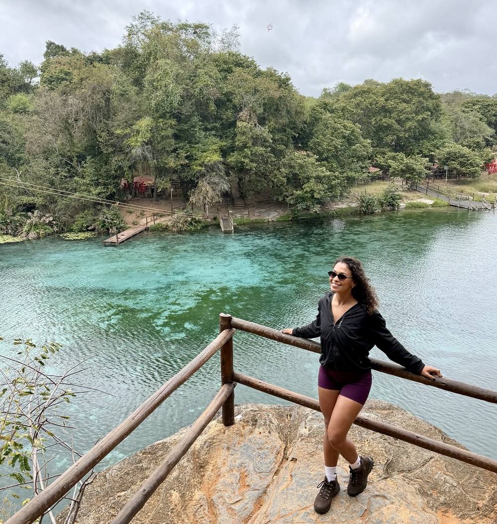 Michele em um mirante sobre um poço de água turquesa
